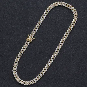 Close-up of golden Cuban link necklace with iced out white zircons on black background