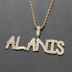 Macro view of iced out custom name pendant with baguette zircons on gold rope chain