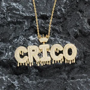 Détail du pendentif CRICO doré avec couronne et zircons sur une chaîne de style corde