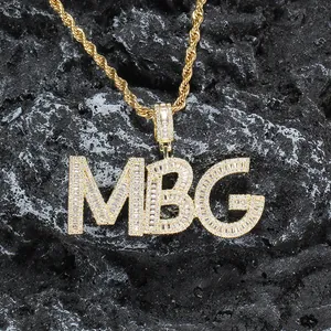 Iced out MBG letter pendant necklace with gold rope chain on black stone background