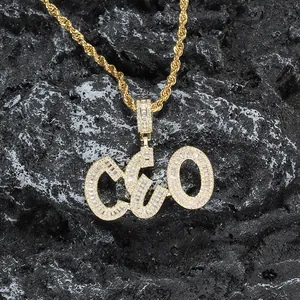 Macro shot of iced out CEO pendant with white zircons on gold rope chain over black rock