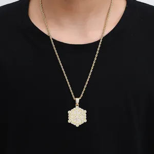 Macro shot of gold snowflake pendant with zircon inlay on a twisted rope chain