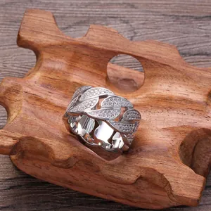 Vue détaillée d'une bague maille cubaine argentée sertie de zircons sur support bois