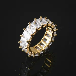 Macro d'une bague éternité dorée avec zircons taille baguette et reflets sur fond noir