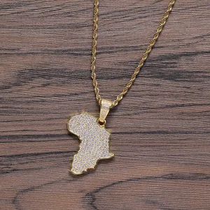 Macro detail of gold Africa map pendant with cubic zirconia stones on rope chain