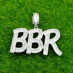 Macro detail of silver iced-out BBR letter pendant with baguette cut cubic zirconia