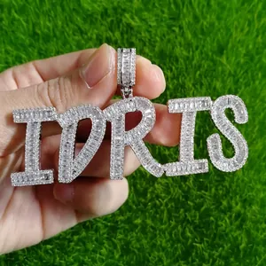 Macro shot of silver hip hop pendant IDRIS with inlaid baguette cut zircons on green turf