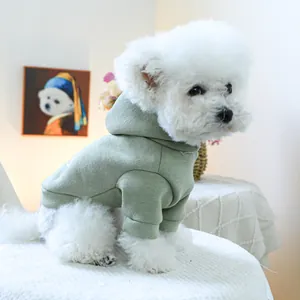 Detail of sage green hooded pet sweatshirt with ribbed cuffs on a white Bichon dog