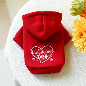 Detail of red Valentine's Day pet hoodie with heart print and white text on knit background