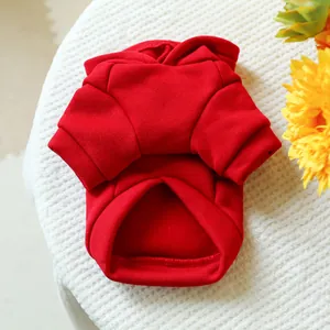 Detail of red pet hoodie with ribbed cuffs on soft white knitted texture