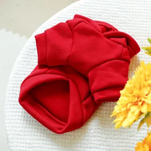 Flat lay of a red hooded pet sweatshirt with fleece lining on white waffle fabric