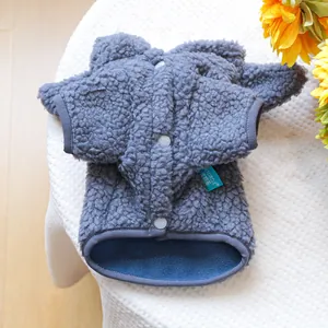 Détail d'un gilet pour animal en polaire sherpa gris foncé avec boutons-pression et étiquette