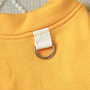 Detailed macro view of vibrant yellow pet dog sweatshirt neckline with metal D-ring