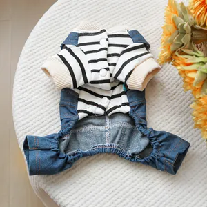 Dettaglio del maglione a righe per animali con salopette in denim e bottoni tondi