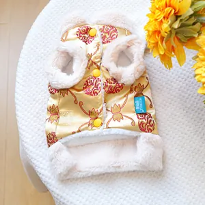 Detailed view of Chinese style pet vest with gold satin fabric and white faux fur trim