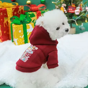 Close-up of a festive burgundy pet hoodie with reindeer print on a white dog