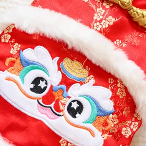 Détail d'une tenue festive rouge pour animaux avec broderie lion et bordure en fourrure