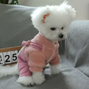 Pink fleece dog jumpsuit with adjustable straps on a textured grey fabric background