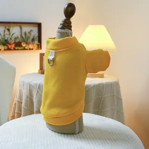 Close-up of yellow dog sweater with ribbed texture and metal D-ring on wood mannequin