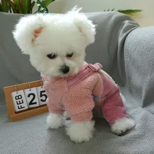 Pink heart pet overalls in plush fleece and corduroy on a white dog sitting on a sofa