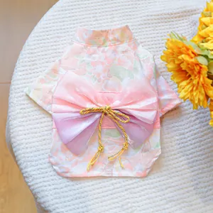 Close-up of floral pet kimono with pink gradient bow and golden knot decoration