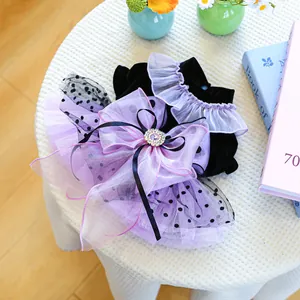 Detail of pet dress with purple organza bow, silk ribbons and a gemstone ornament