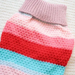 Detail of colorful striped pet sweater with thick knit texture and purple ribbed collar