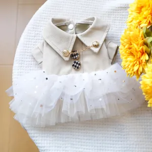 Détail de robe pour chat avec col en similicuir beige, boutons dorés et tulle à paillettes