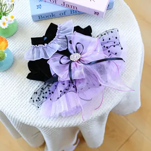 Detail of pet lace collar with purple polka dot bow and gem on black velvet dress