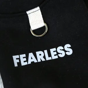 Detail von schwarzem Hundegeschirr mit silbernem D-Ring und weißem FEARLESS Aufdruck