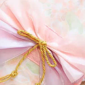 Macro detail of Japanese style pink floral pet kimono with organza bow and golden cord