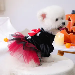 Bichon dog wearing a Halloween pet dress with bone print and red mesh skirt