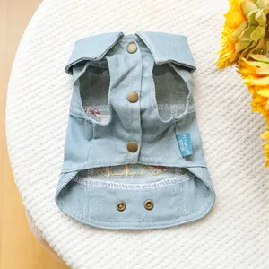 Detail view of light blue denim pet vest with bronze buttons and sunflower prop