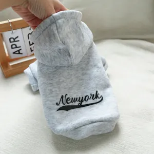 Close-up of a grey Newyork letter print dog hoodie with soft fleece fabric on a sofa