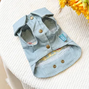 Close-up of light blue pet denim vest featuring vintage metal buttons and brand label