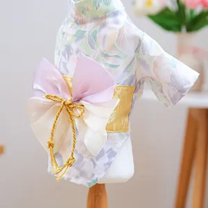 Detailed close-up of pet kimono featuring a satin purple bow and floral green fabric