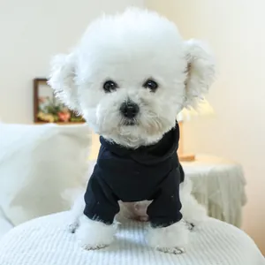 Close-up of black pet hoodie fabric detail on a small white dog in home setting