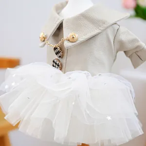 Détail d'une robe pour chien en cuir beige avec boutons dorés et jupe en tulle étoilé