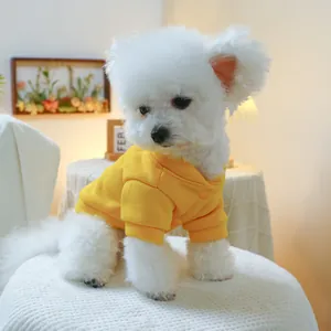 Detail of yellow pet sweatshirt featuring snap buttons and ribbed cuffs on a dog
