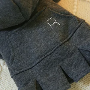 Macro detail of dark grey pet sweatshirt featuring a white dotted embroidered R letter