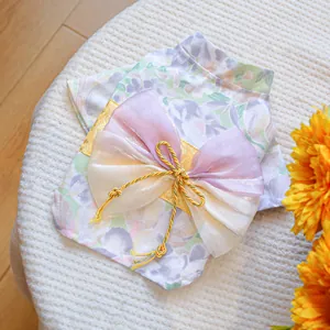 Detailed close-up of floral pet kimono featuring an organza bow and golden tassel knot