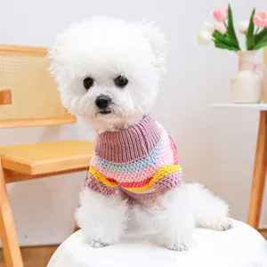 Colorful striped high-neck knitted sweater for small dogs and cats on a white stool