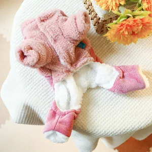 Detail of pink fleece pet overall with warm lining and blue brand label on waffle fabric
