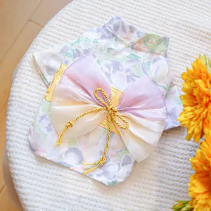 Detailed view of pet kimono featuring a golden brocade obi and large lavender mesh bow