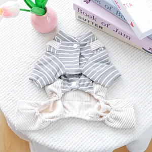 Detail of gray striped dog jumpsuit with cream ribbed pants on a soft textured rug