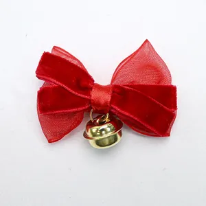 Detail of red velvet bow and translucent mesh with a polished gold metal bell