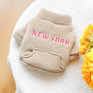 Dettaglio del ricamo New York su felpa kaki per cani con tasca frontale e trama a coste