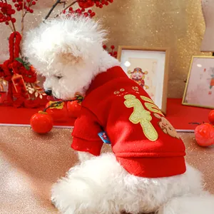Detail of red pet New Year vest with golden Fu character and rabbit embroidery