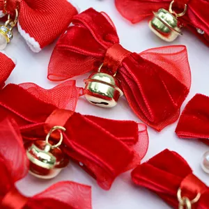 Detail of red velvet bow with organza layers and a gold bell for pet hair accessory