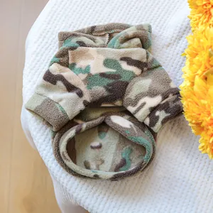 Détail de la veste en polaire camouflage pour animaux avec coutures de qualité sur tissu blanc